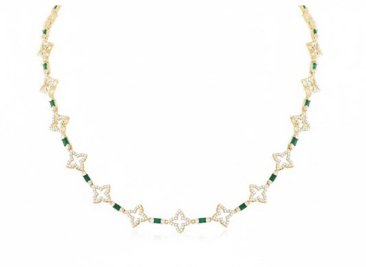 Gold necklace with green gemstones on a white background