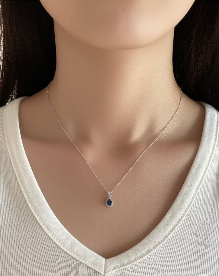 Model wearing pear-shaped blue topaz birthstone necklace
