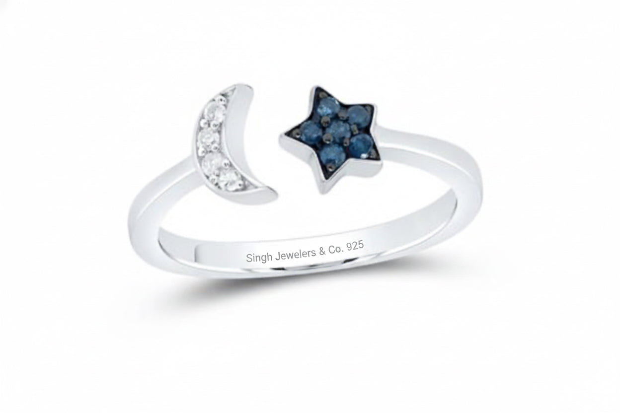 Close-up of celestial sterling silver ring featuring star and moon design with blue sapphires.
