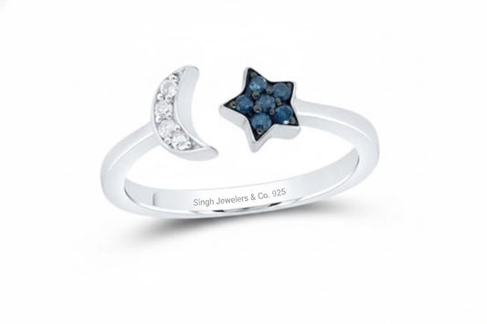 Close-up of celestial sterling silver ring featuring star and moon design with blue sapphires.