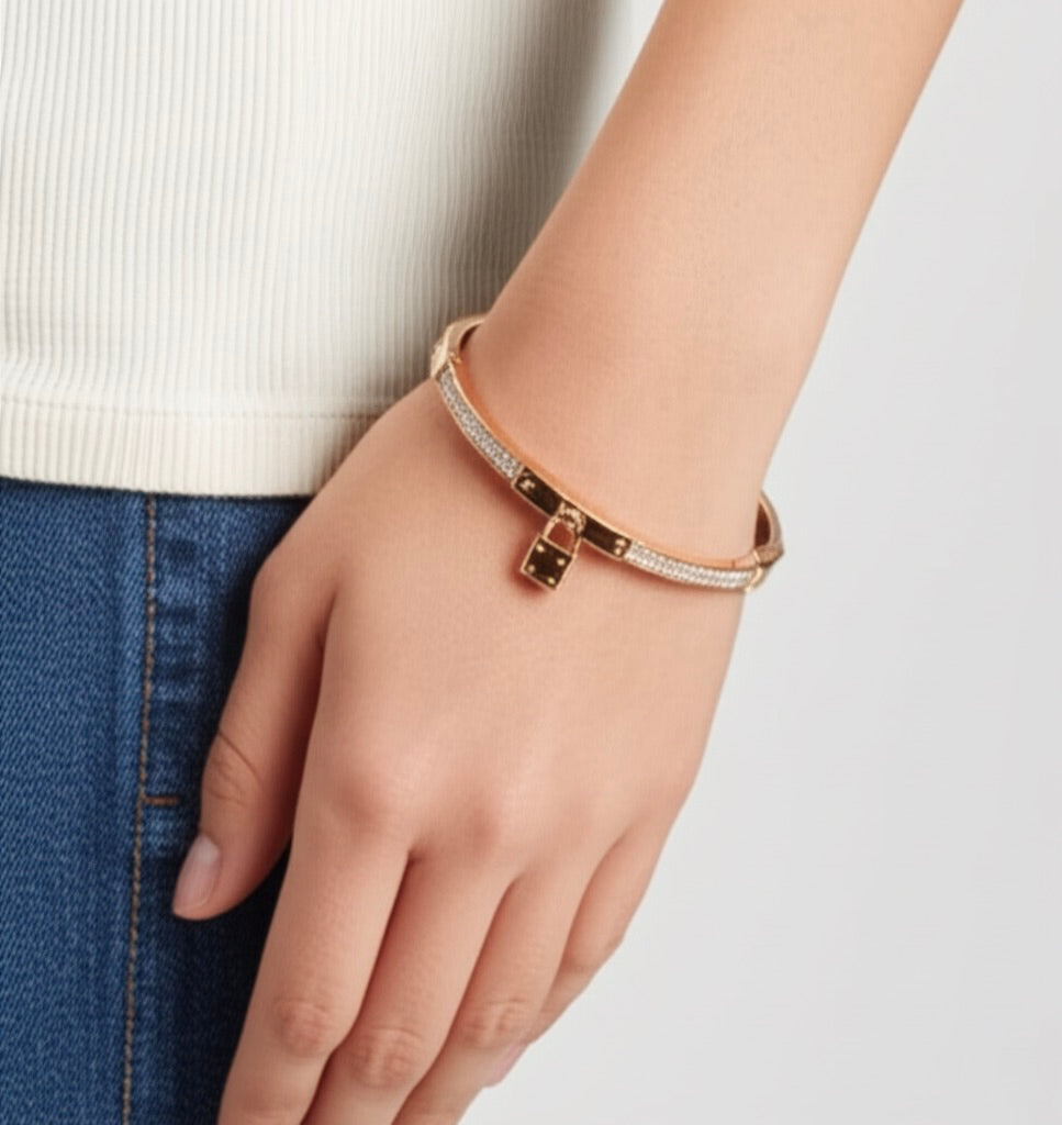 Stainless steel bangle with gold-tone finish featuring the Michael Kors logo, offering a stylish and modern design.