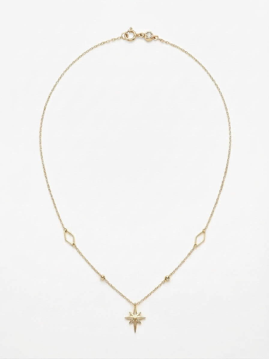 10K yellow gold paperclip link necklace featuring a radiant starburst pendant, geometric stations, and a 17-inch chain with a 1-inch extender.
