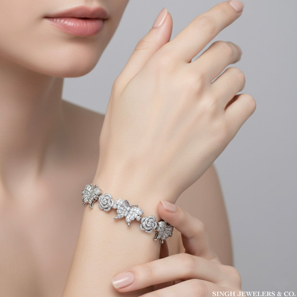 Silver bracelet with floral design on a wrist, brand 'Singh Jewelers & Co.' visible