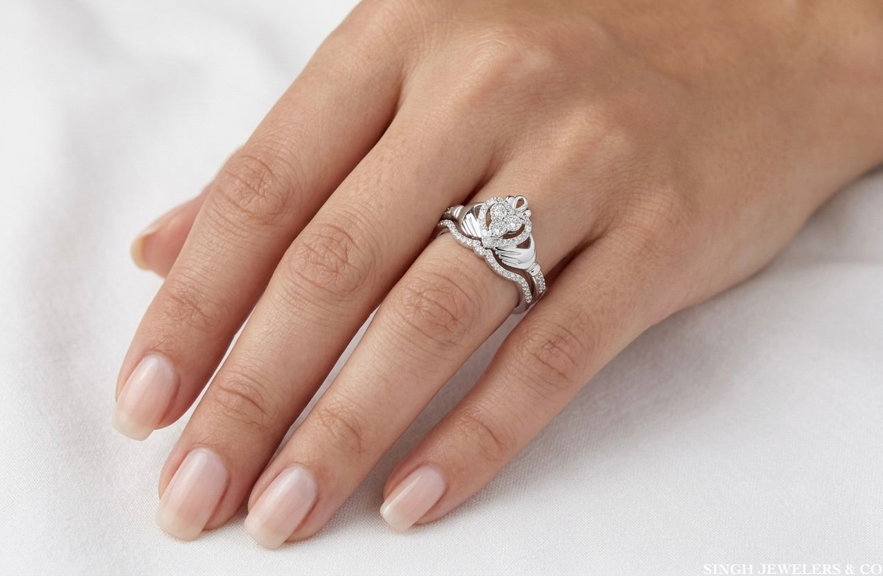 Close-up of a hand wearing a silver ring with a diamond on a white background
