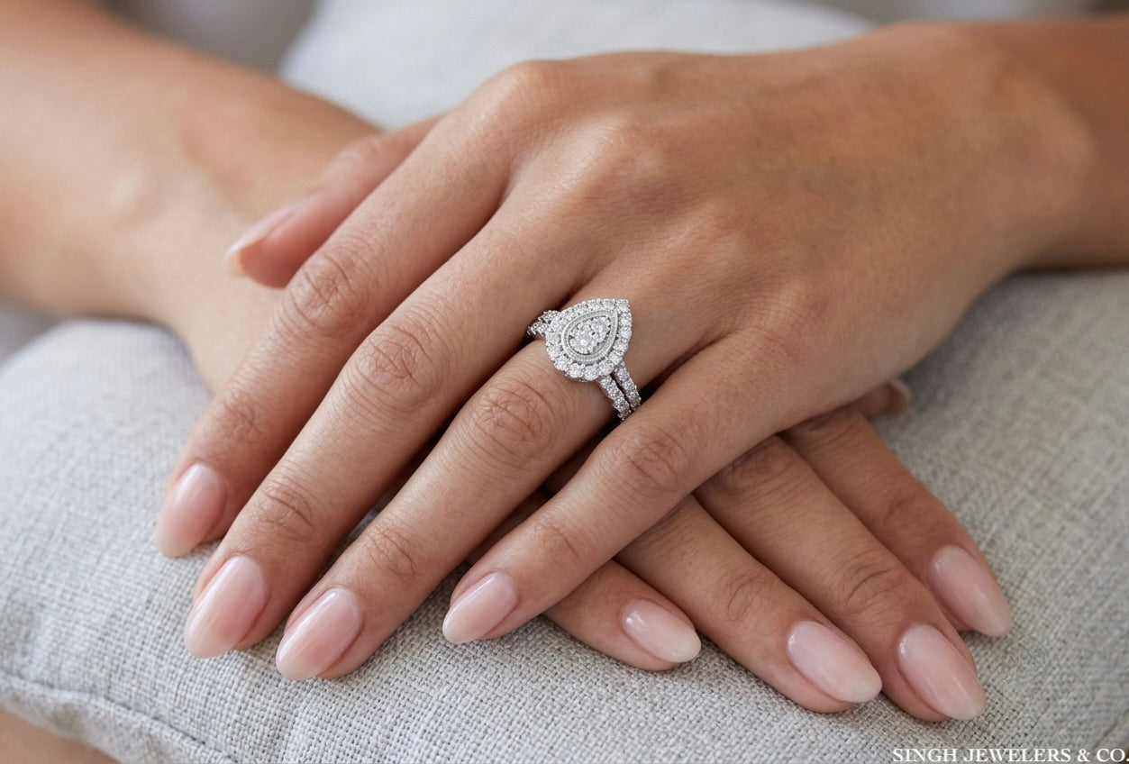 Close-up of a hand wearing a diamond ring on a neutral background