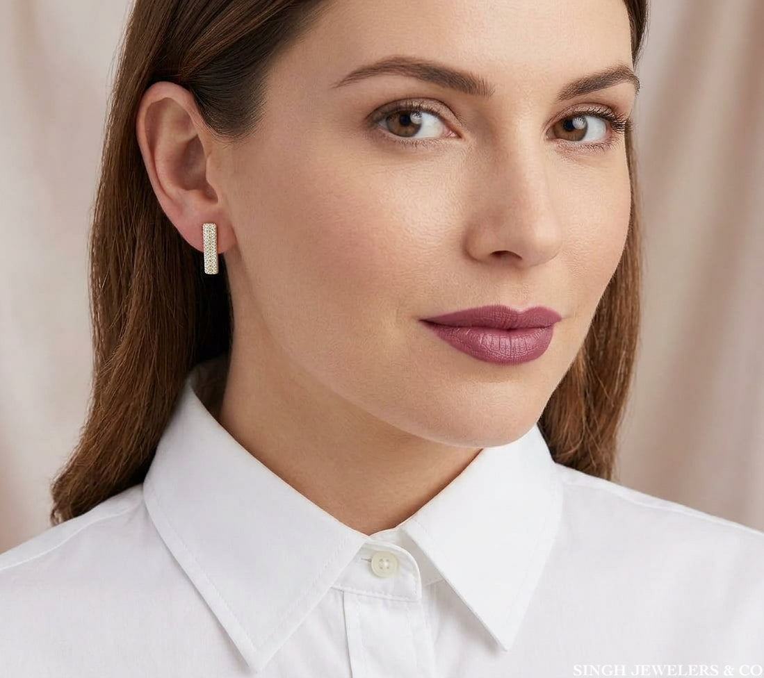 14K yellow gold elongated bar stud earrings with cubic zirconia modeled on the ear